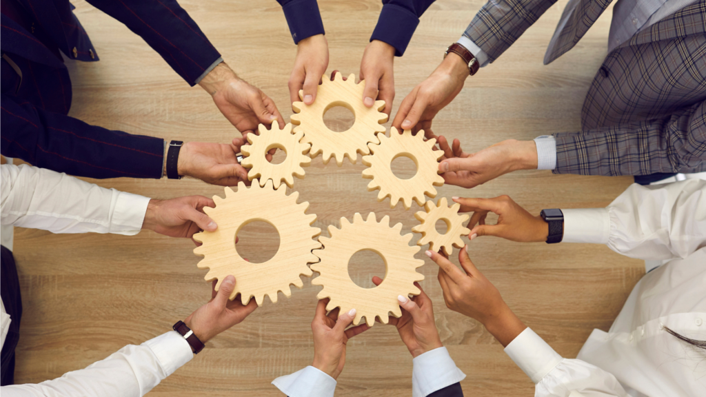 A team holding wooden gears together
