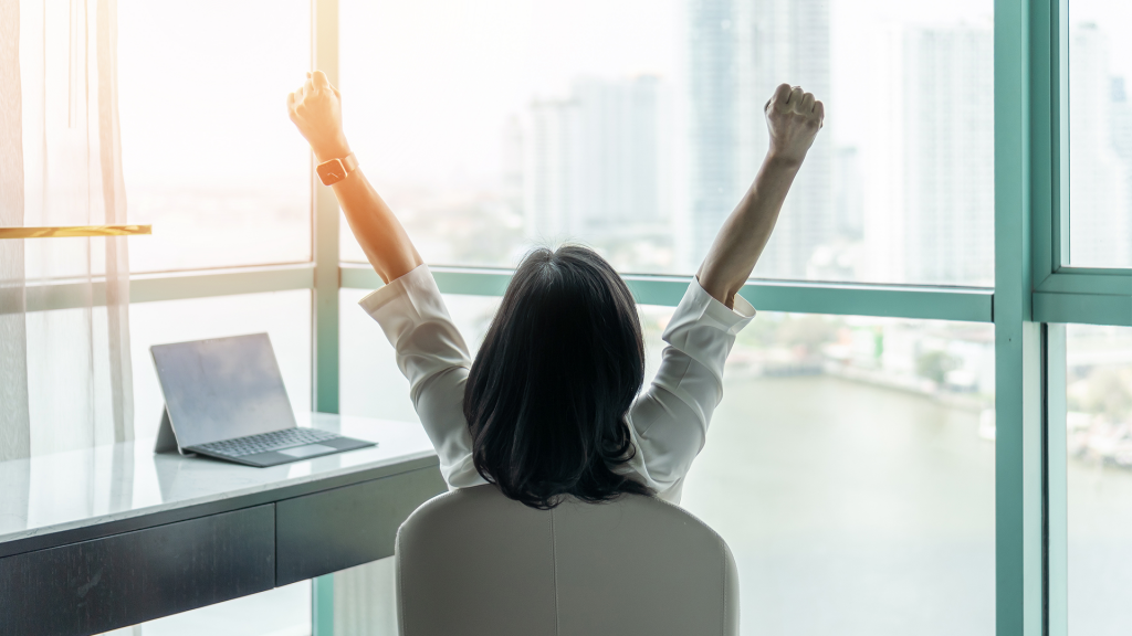 A person raising their arms in celebration at an office