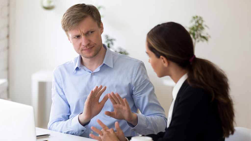 Two people having a defensive work conversation