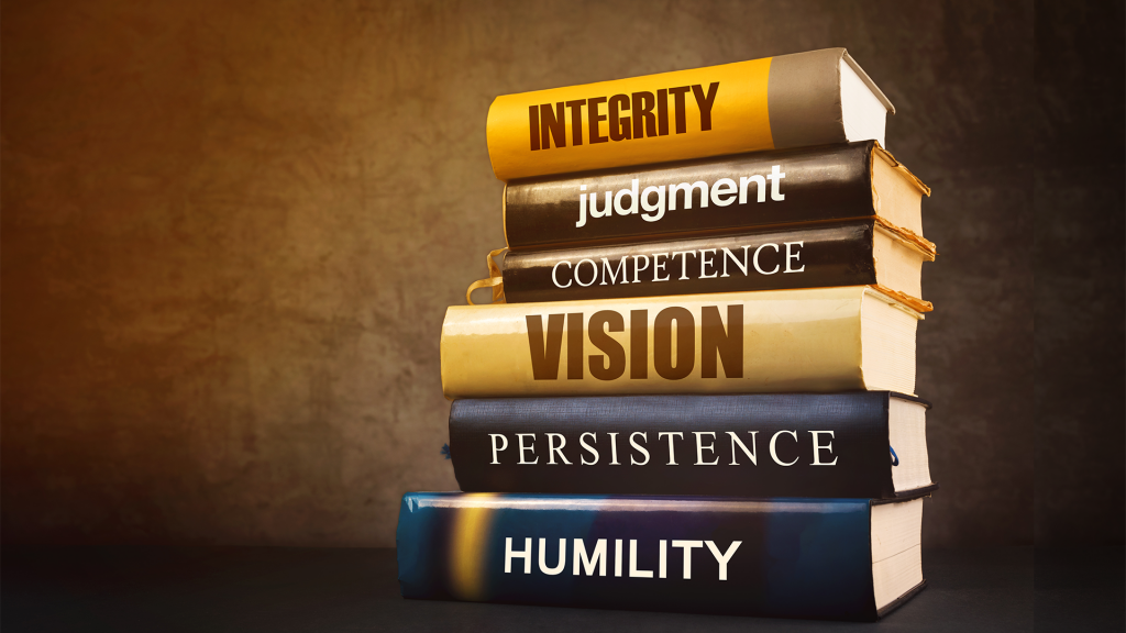 Stack of books with our core principles printed on the spine